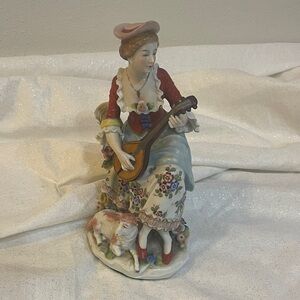 Vintage porcelain figurine of Woman in Victorian style attire playing mandolin